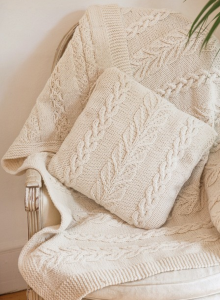 Cream colored cable and leaf knit cushion cover